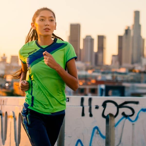 Female runner in LA running with a green and blue Joma t-shirt on