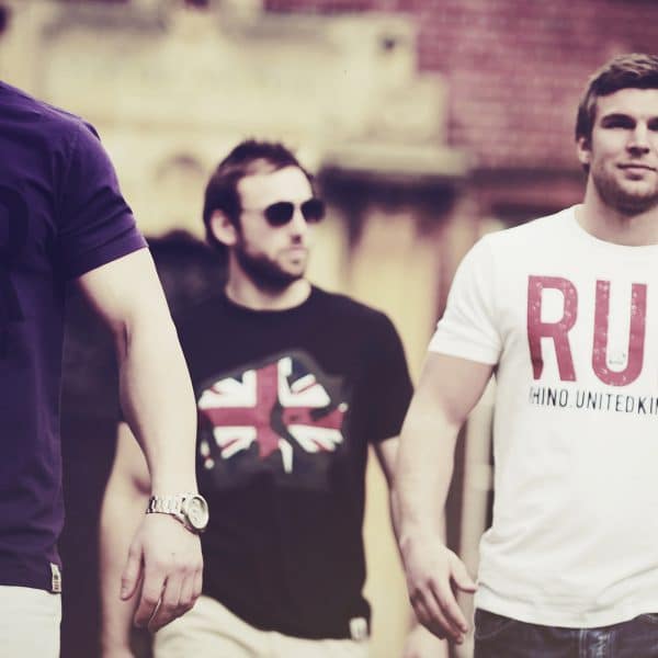 Three mean wearing Rhino Rugby T-shirts whilst walking