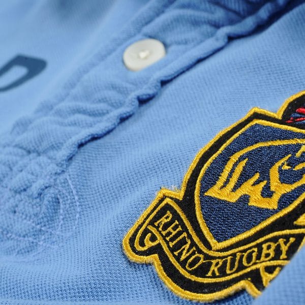 Close up photograph of a Rhino Rugby badge on a polo shirt