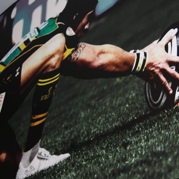 Northampton Rugby club shop banners with a player holding a ball
